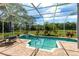 Inviting screened-in pool and spa area with brick pavers and a view of the lush backyard at 1312 Winter Springs Blvd, Winter Springs, FL 32708