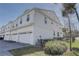 View of the side and back of this white, multi-level house with attached garages at 1401 E Michigan St, Orlando, FL 32806