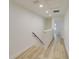 Hallway with wood-look floors and white walls leads to a bright bedroom at 1401 E Michigan St, Orlando, FL 32806