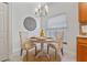 Charming dining area with round table, chandelier, and decorative wall art near the kitchen at 14149 Paradise Tree Dr, Orlando, FL 32828