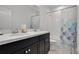 Bathroom showcasing a vanity with double sinks and a shower with a blue and white patterned curtain at 14214 Shocklach Dr, Winter Garden, FL 34787
