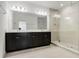 Modern bathroom featuring dual vanity, a large mirror, and frameless glass shower at 14214 Shocklach Dr, Winter Garden, FL 34787