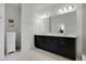 Bright bathroom features a double vanity with dark cabinets and a large, well-lit mirror at 14214 Shocklach Dr, Winter Garden, FL 34787