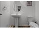 Bathroom showing a pedestal sink, toilet, framed art, and wood-look flooring at 14214 Shocklach Dr, Winter Garden, FL 34787