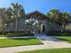 Community clubhouse entrance featuring a modern design, walkway, and lush tropical landscaping at 14214 Shocklach Dr, Winter Garden, FL 34787