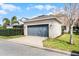 A detached two car garage with a gray door sits on the driveway next to manicured landscaping at 14214 Shocklach Dr, Winter Garden, FL 34787