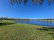A serene pond reflecting the sky is surrounded by lush green grass and distant trees at 14214 Shocklach Dr, Winter Garden, FL 34787