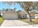 Inviting single-story home with a neatly maintained lawn, mature trees, and a two-car garage at 154 Desiree Aurora St, Winter Garden, FL 34787