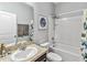 Cozy bathroom with granite vanity, framed mirror, shower with tub and butterfly curtain at 16390 Blooming Cherry Dr, Groveland, FL 34736