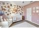 Stylish Bedroom with butterfly wall decor, white crib, comfortable seating and ample lighting at 16390 Blooming Cherry Dr, Groveland, FL 34736