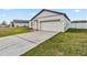 Charming single-Gathering home with a well-maintained lawn and a driveway leading to a two-car garage at 16390 Blooming Cherry Dr, Groveland, FL 34736
