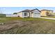 A neatly kept single-Gathering home with a two-car garage, adjacent to a fenced yard and green lawn at 16390 Blooming Cherry Dr, Groveland, FL 34736
