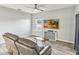 Living room with wood-look floors, modern ceiling fan, leather sofa, and flat screen television at 16390 Blooming Cherry Dr, Groveland, FL 34736
