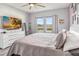 Comfortable main bedroom with large windows, dresser, and a ceiling fan at 16390 Blooming Cherry Dr, Groveland, FL 34736