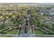 The aerial view shows the entrance to a neighborhood with mature trees and landscaping at 182 Crepe Myrtle Dr, Groveland, FL 34736