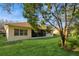 Lush backyard featuring healthy green grass, mature trees, and the exterior of the home at 182 Crepe Myrtle Dr, Groveland, FL 34736