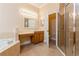 Elegant bathroom with large tub, glass-enclosed shower, double sinks, and makeup vanity at 182 Crepe Myrtle Dr, Groveland, FL 34736