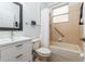 Bathroom featuring a white vanity, mirror, toilet, and a shower-tub combination with neutral tiling at 182 Crepe Myrtle Dr, Groveland, FL 34736
