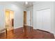 Bright bedroom featuring hardwood floors, white trim, and a closet for ample storage space at 182 Crepe Myrtle Dr, Groveland, FL 34736