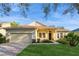 Charming single-story home with well-manicured lawn, a brick driveway, and neutral tan color at 182 Crepe Myrtle Dr, Groveland, FL 34736