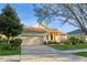 Attractive home with a well-maintained lawn and brick driveway, and a two-car garage at 182 Crepe Myrtle Dr, Groveland, FL 34736