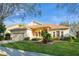 Inviting single-story home with lush green lawn, brick driveway, and well-maintained landscaping at 182 Crepe Myrtle Dr, Groveland, FL 34736