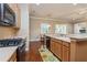 Open kitchen with wood cabinets, stainless steel appliances, and hardwood floors at 182 Crepe Myrtle Dr, Groveland, FL 34736