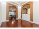 Spacious living area with arched entryways, hardwood floors, and seamless flow into other living spaces at 182 Crepe Myrtle Dr, Groveland, FL 34736
