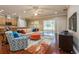 Open-concept living room featuring hardwood floors, a large sectional, and sliding glass doors to the outdoors at 182 Crepe Myrtle Dr, Groveland, FL 34736