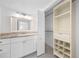 Bathroom with tiled floor, granite counters, walk-in closet with shelving, and vanity mirror at 200 Maitland Ave # 131, Altamonte Springs, FL 32701