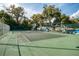Community tennis court surrounded by trees and green fencing at 200 Maitland Ave # 131, Altamonte Springs, FL 32701