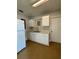 A simple kitchen area featuring basic cabinets, sink, and white refrigerator at 2426 Barbarossa Ave, Deltona, FL 32738