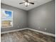 This bedroom features wood-look tile floors and a window for natural light at 2439 Lake Jackson Cir, Apopka, FL 32703