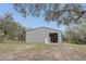 Exterior view of gray metal barn with two doors, one roll-up and one pedestrian at 255 Butterfly Forest Rd, Geneva, FL 32732