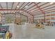 View of the barn interior with roll-up door and exposed ceiling at 255 Butterfly Forest Rd, Geneva, FL 32732