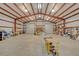 View of the barn interior with exposed rafters, shelving, and roll-up doors at 255 Butterfly Forest Rd, Geneva, FL 32732