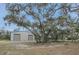 A large metal barn with trees with Spanish moss and a dirt drive at 255 Butterfly Forest Rd, Geneva, FL 32732