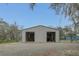 Exterior view of the gray metal barn with two roll-up doors open at 255 Butterfly Forest Rd, Geneva, FL 32732