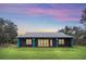 Stunning exterior view of a single-story home with a lush green lawn at sunset at 255 Butterfly Forest Rd, Geneva, FL 32732