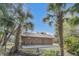Quaint home nestled between palm trees, with rocking chairs on the porch at 255 Butterfly Forest Rd, Geneva, FL 32732