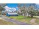 Charming blue home with a metal roof and inviting screened porch surrounded by lush greenery at 255 Butterfly Forest Rd, Geneva, FL 32732