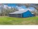 Charming blue home features a screened in porch, metal roof, and lush landscaping at 255 Butterfly Forest Rd, Geneva, FL 32732