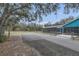 Wide driveway leads to the screened porch and house, bordered by mature oak trees at 255 Butterfly Forest Rd, Geneva, FL 32732