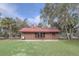 Quaint home with a durable red metal roof, complemented by a well-maintained lawn and natural landscaping at 255 Butterfly Forest Rd, Geneva, FL 32732