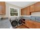 Well-lit laundry room featuring modern machines, ample counter space, and wood cabinets at 255 Butterfly Forest Rd, Geneva, FL 32732