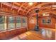 Bright, wood-paneled living space with large windows, a classic wood-burning stove, and natural light at 255 Butterfly Forest Rd, Geneva, FL 32732