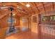 Open-concept living space features wood paneled walls and ceilings, a wood stove, and natural light at 255 Butterfly Forest Rd, Geneva, FL 32732
