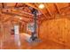 Wood-paneled living area showcasing a rustic wood stove, a refrigerator, and bright lighting fixtures at 255 Butterfly Forest Rd, Geneva, FL 32732