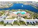 Aerial view of the community pool and clubhouse surrounded by a scenic lake and manicured landscaping at 2890 Avian Loop, Kissimmee, FL 34741