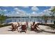 Outdoor fire pit area with Adirondack chairs overlooking a serene lake with fountain at 2890 Avian Loop, Kissimmee, FL 34741